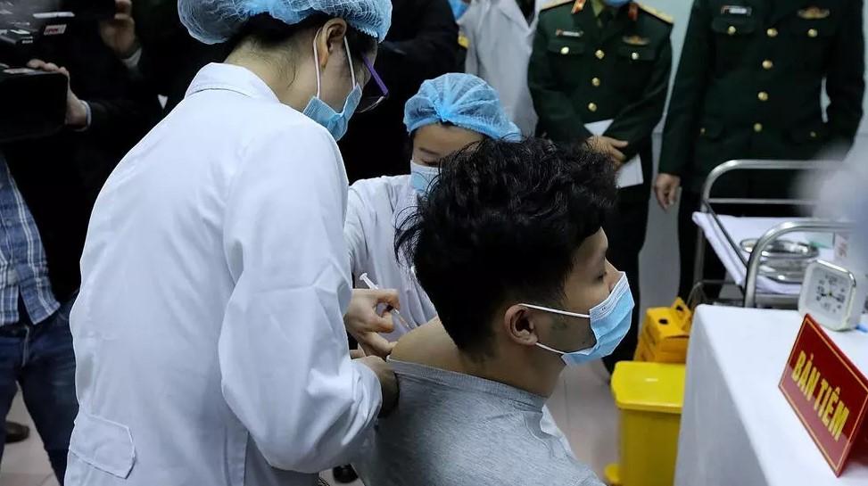 Vietnamese military medical officials administer a shot of the Covid-19 vaccine Nanocovax to a volunteer in Hanoi - Avaz