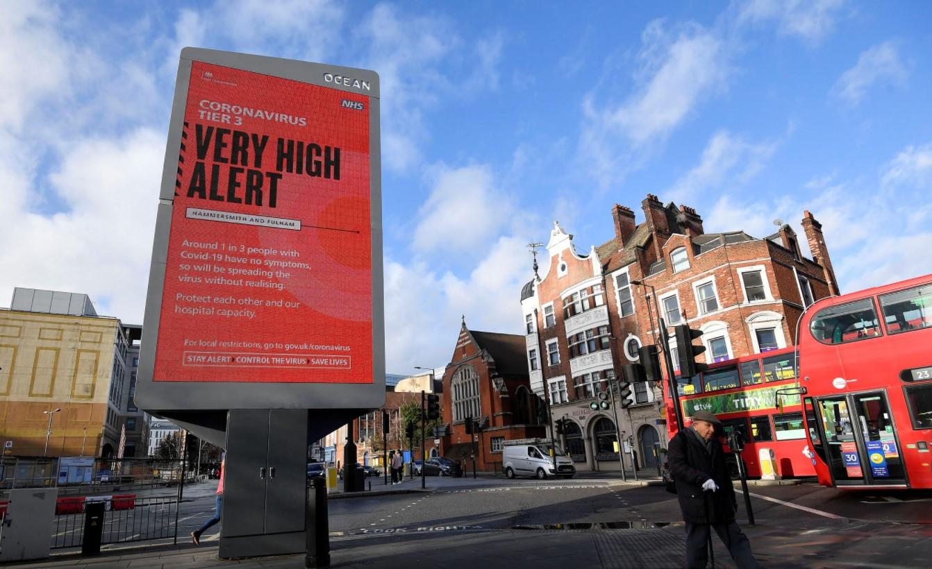 Pedestrians walk past a British government health information advertisement highlighting new restrictions amid the spread of the coronavirus disease (COVID-19), London, Britain, December 19, 2020. - Avaz