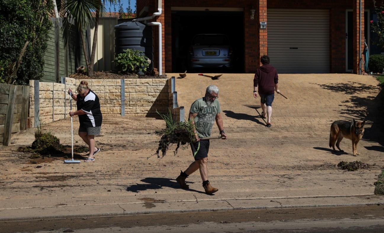 Local residents clean up debris in the aftermath of the area getting inundated with floodwaters following prolonged rains and a severe weather event in the suburb of McGraths Hill in Sydney, Australia, March 26, 2021. - Avaz