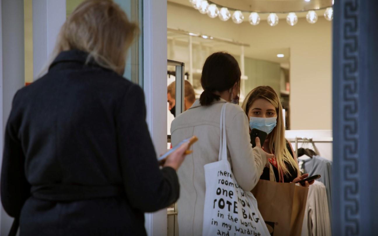 A woman wearing a protective mask walks by a shop on the first day of the re-opening of retail stores, amid the coronavirus disease (COVID-19) pandemic, in Athens, Greece, April 5, 2021. - Avaz