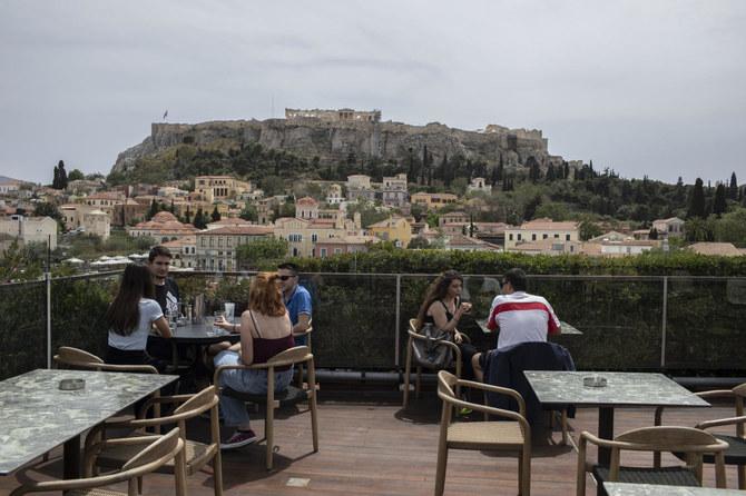 People sit in on a cafe terrace in the Monastiraki district of Athens in Greece that will reopen private beaches on Saturday and museums next week while travel restart May 15 - Avaz