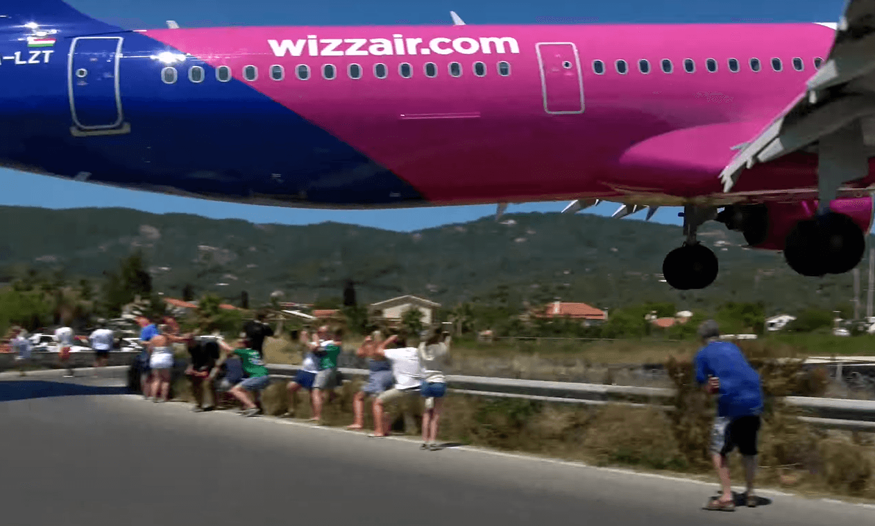 Avion slijeće na nekoliko desetina metara od plaže, ljudi se saginju, žene padaju na leđa