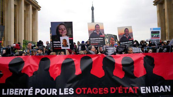 People hold portraits of French detainees in Iran Cecile Kohler, left, and Benjamin Briere during a protest in Paris, Saturday, Jan. 28, 2023.  - Avaz