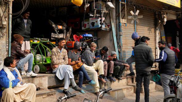 Shopkeepers and workers wait for electric power at a market following a power breakdown across the country, in Lahore, Pakistan - Avaz